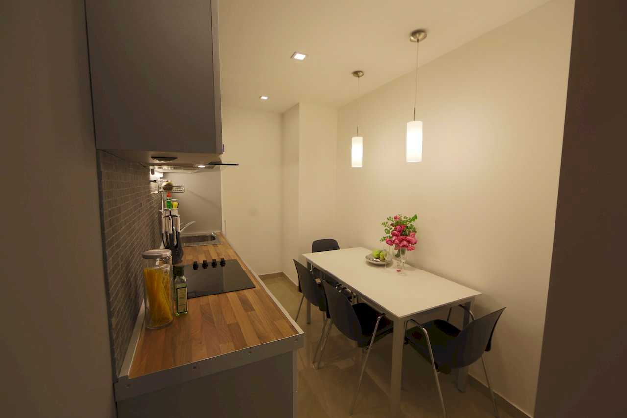 Apartment Taš 2 (King Alexander Boulevard, Tašmajdan, Belgrade) – kitchen and dining area with white table, four black chairs, pendants and roses