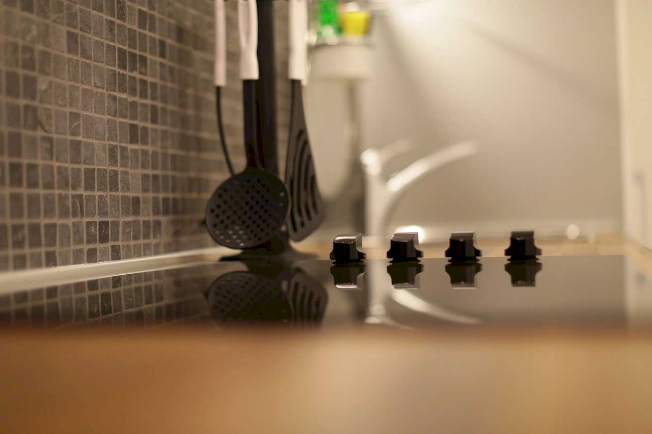 Apartment Taš 2 (King Alexander Boulevard, Tašmajdan, Belgrade) – kitchen detail: ceramic hob with knobs and hanging utensils above