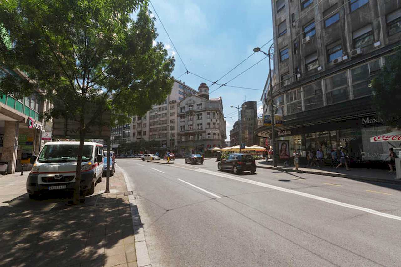 View of Kolarčeva and the centre: street, pavement, shopfronts (Max Mara, Maxi), pedestrians and traffic – Apartment Trg 1 – City Break Apartments