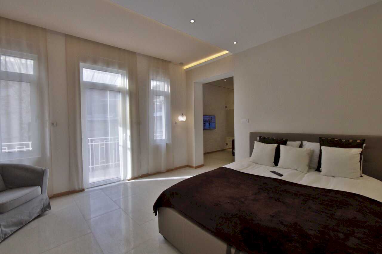Apartman Twin 1 (Carice Milice, centar Beograda) – spavaća soba sa bračnim krevetom, francuskim balkonom sa svetlim zavesama i prolazom ka dnevnom boravku