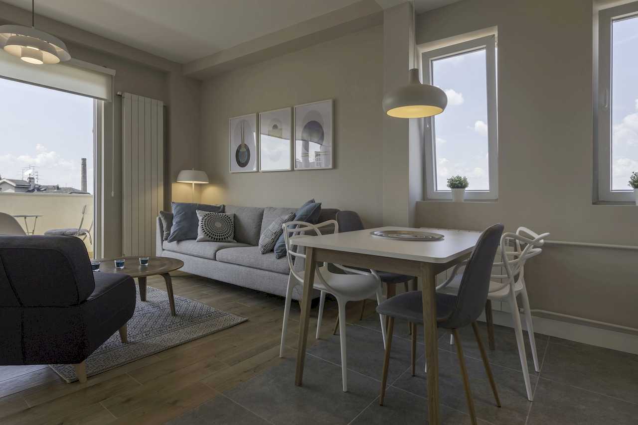 Living room and dining area by large windows – Apartment Urban Zen – City Break Apartments