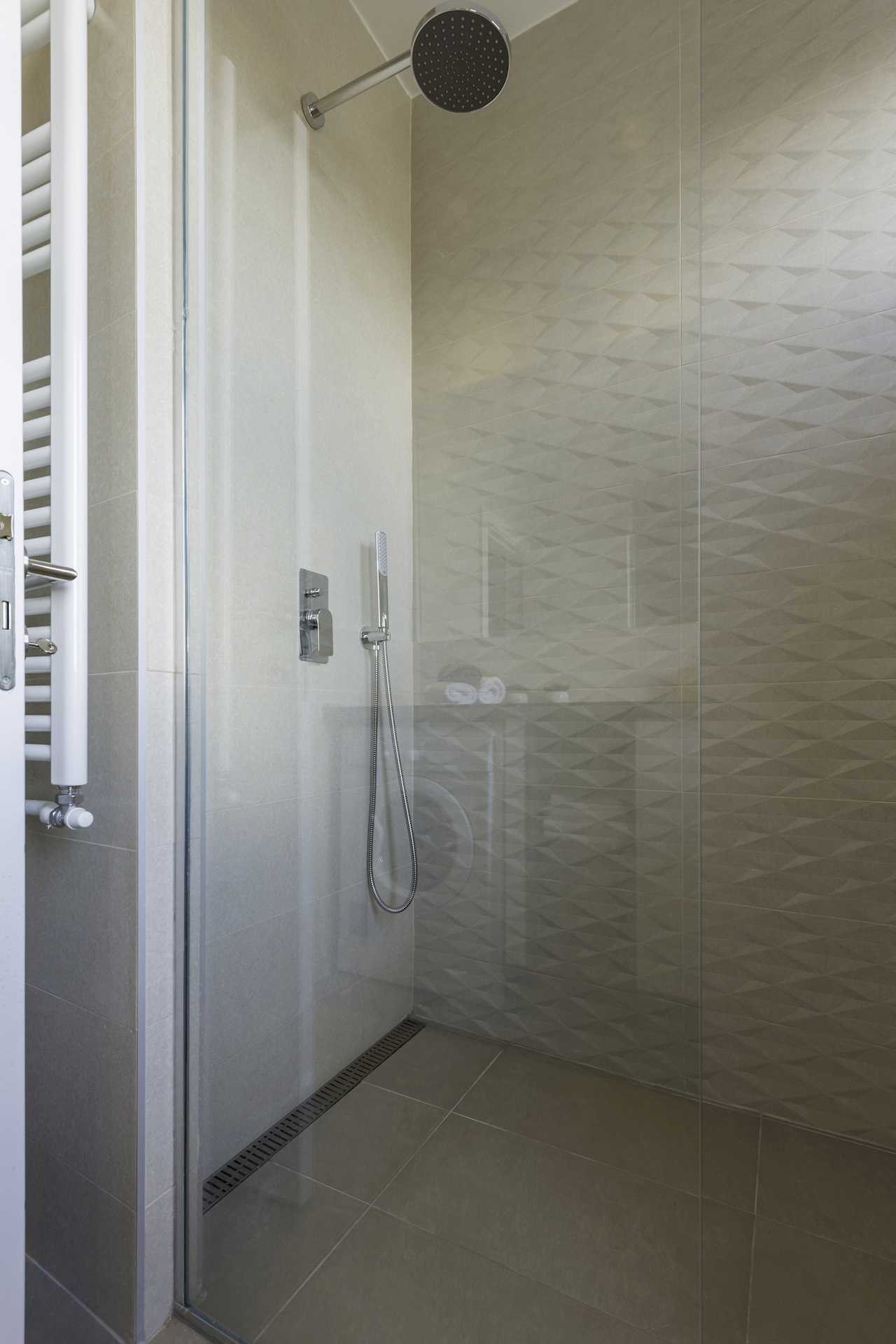 Walk-in shower with rainfall shower head and glass partition – Apartment Urban Zen – City Break Apartments