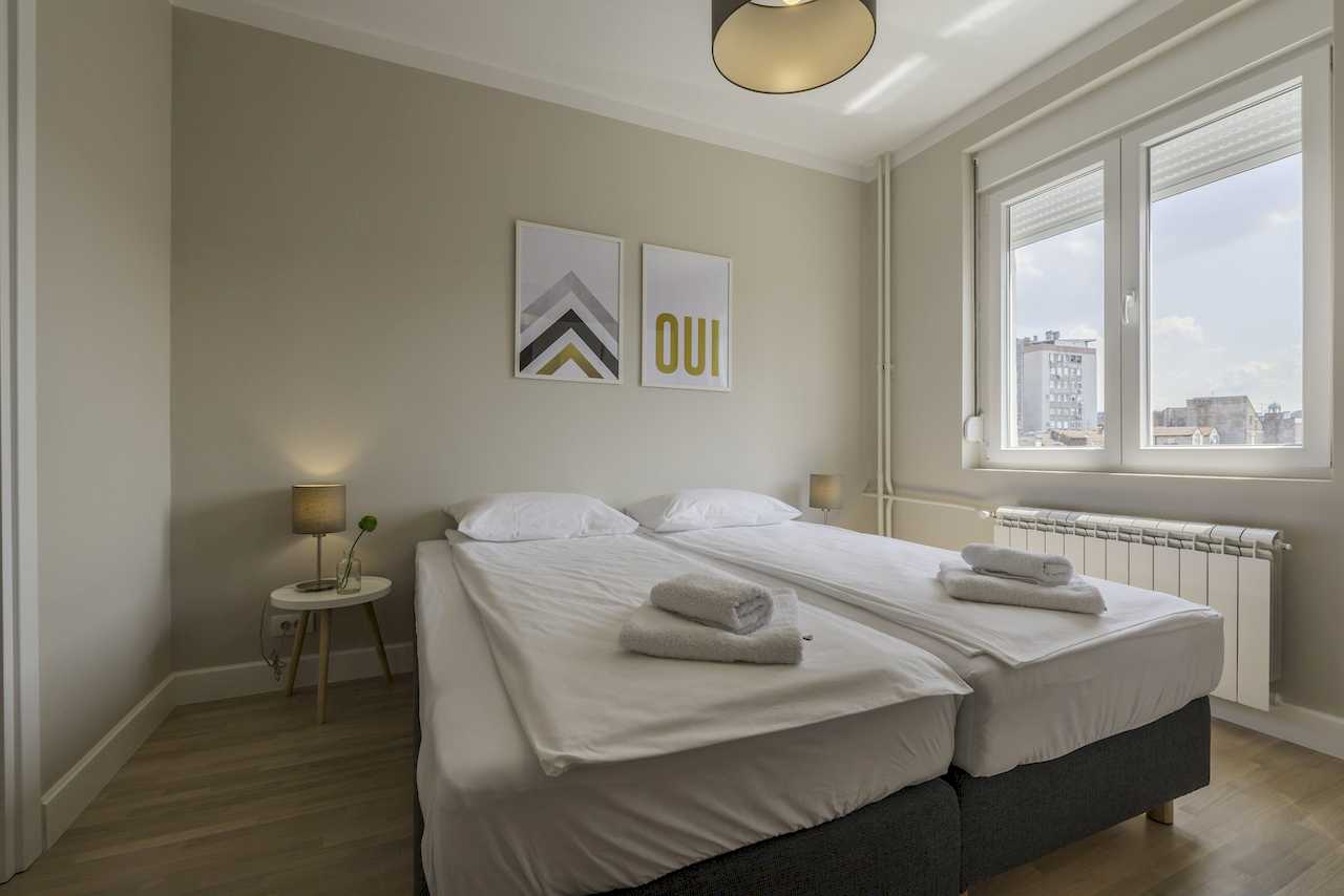 Bedroom with two beds and large window – Apartment Urban Zen – City Break Apartments