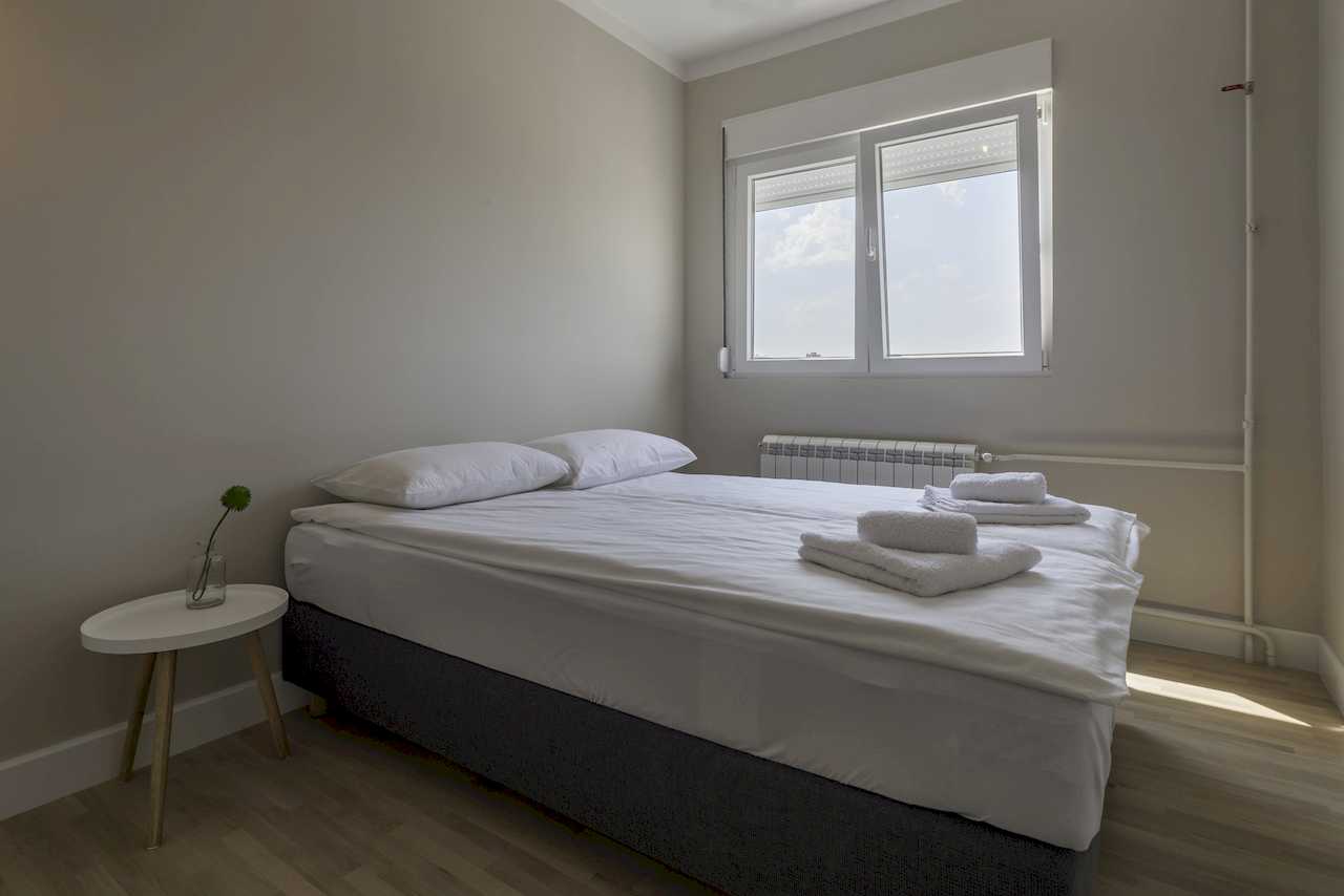 Bedroom with double bed and bedside table – Apartment Urban Zen – City Break Apartments