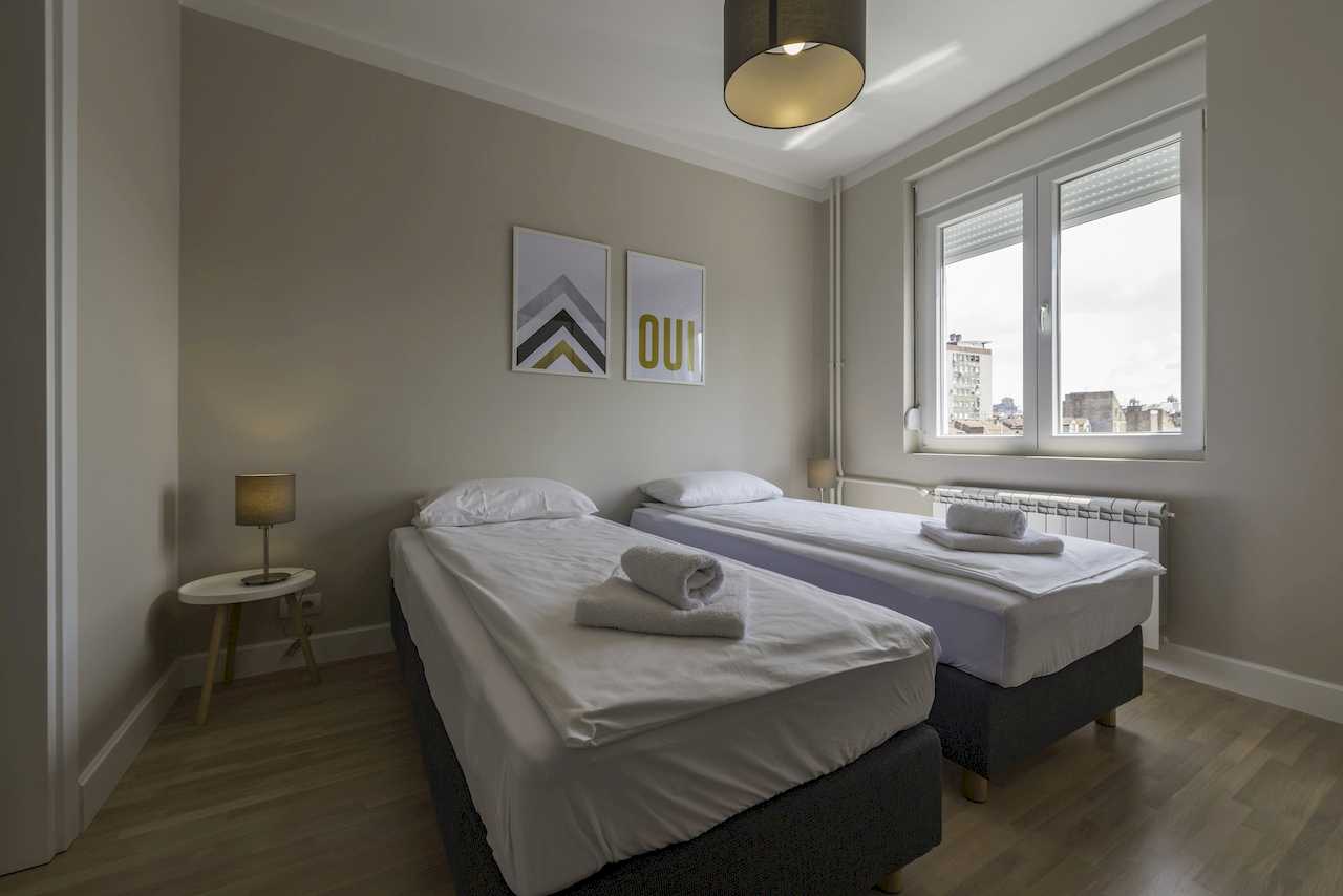 Twin bedroom with two single beds and window – Apartment Urban Zen – City Break Apartments