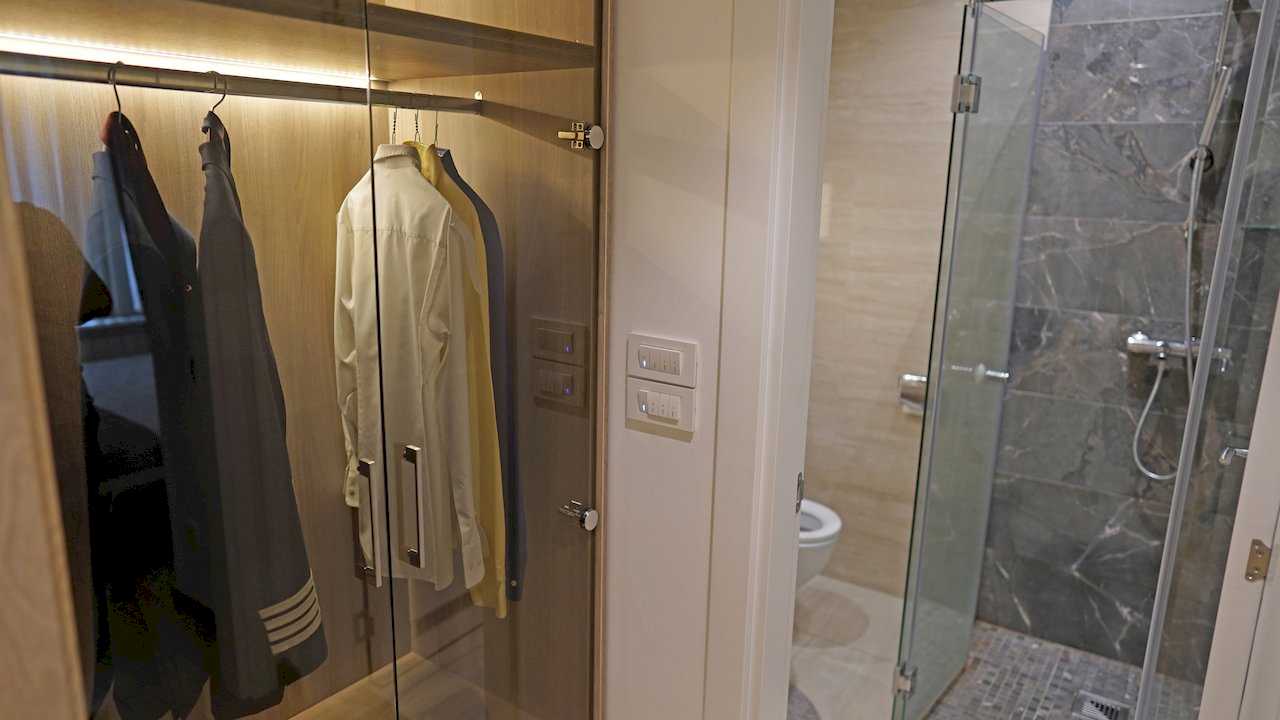 Apartment Vuk (Vuk's Monument, Belgrade) – built-in wardrobe with glass doors and view of bathroom with shower enclosure
