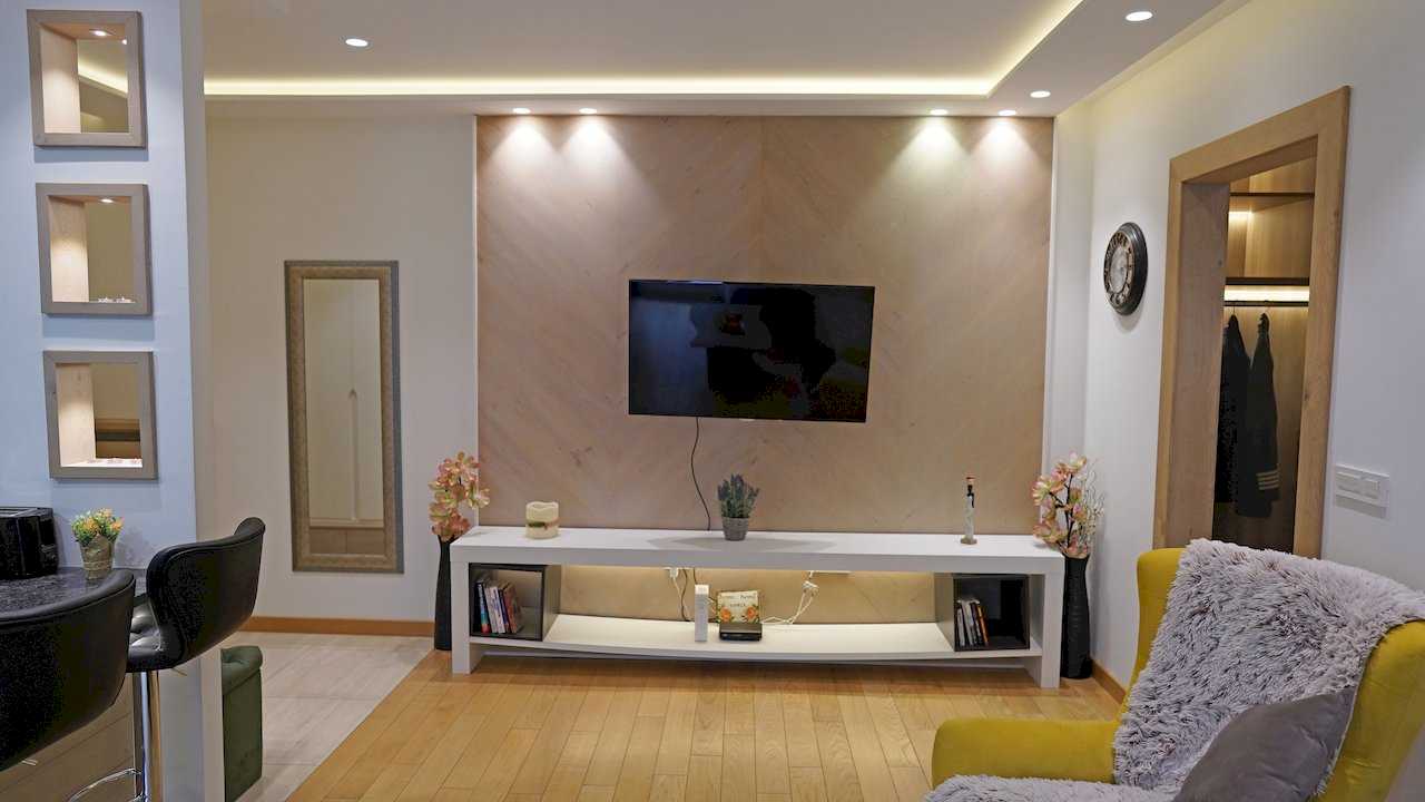 Apartment Vuk (Vuk's Monument, Belgrade) – living room with TV on wood panel, white console and yellow armchair