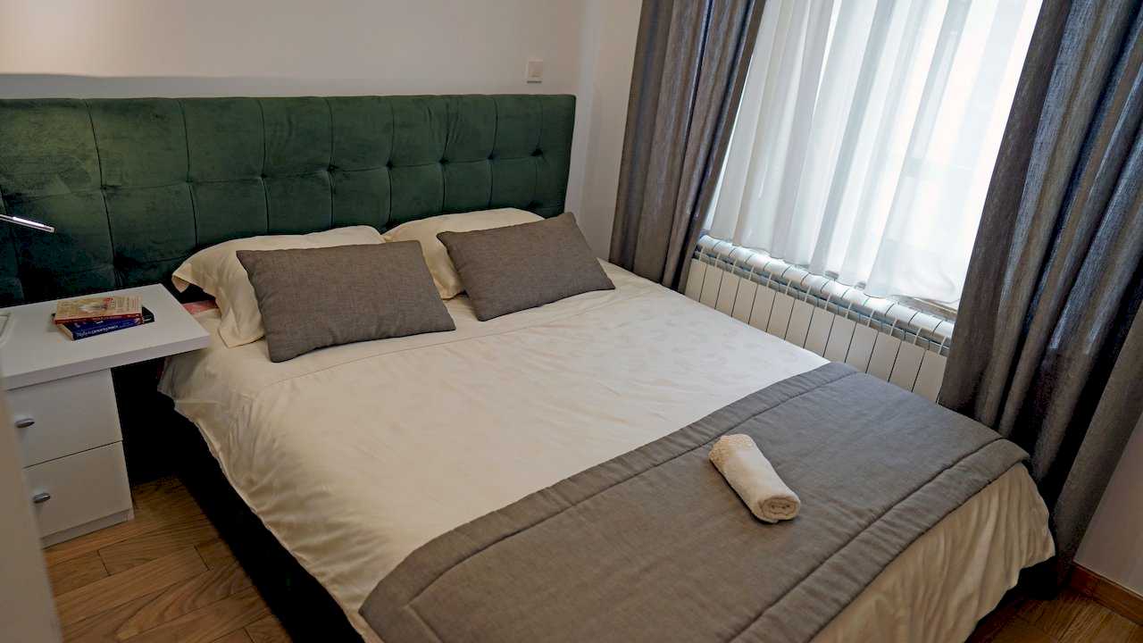 Apartment Vuk (Vuk's Monument, Belgrade) – bedroom with double bed and dark green headboard