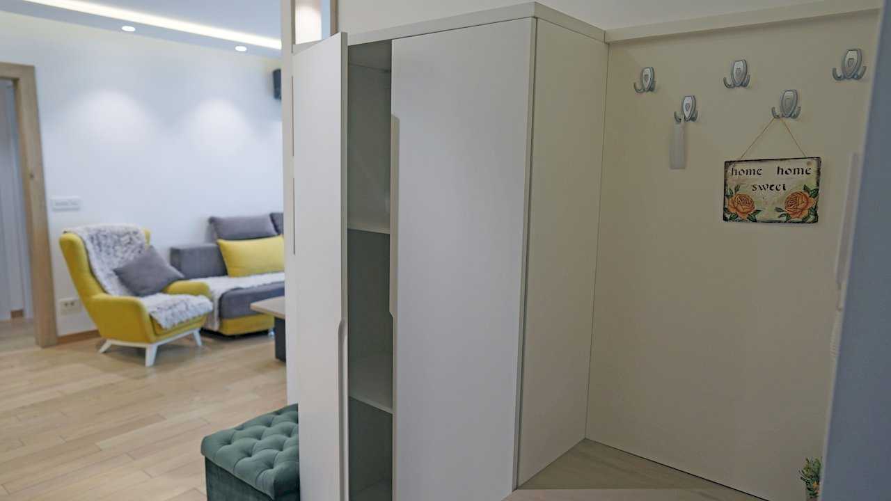 Apartment Vuk (Vuk's Monument, Belgrade) – entryway with white wardrobe and view of living room